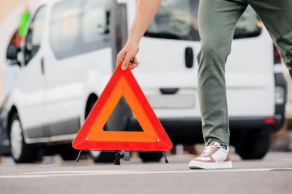 Mann, der rotes Notstoppschild auf der Straße platziert